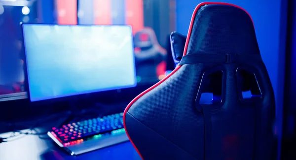 Rows of PCs seen through the PIXELPET club window past a neon Open sign and an hourly rates board