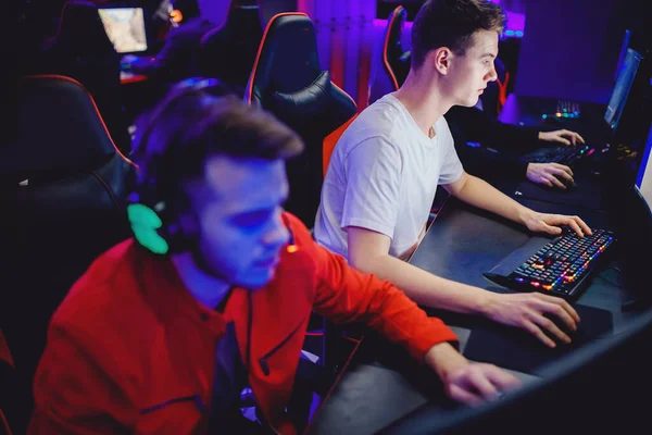 Two friends sharing a duo desk at PIXELPET, co-op play side by side